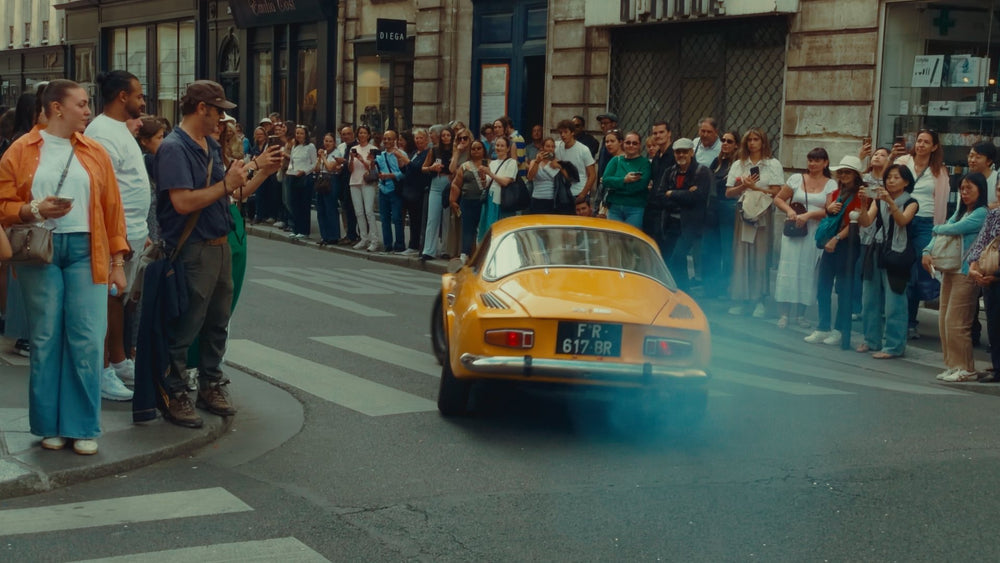 Crowd watching a yellow classic car graded with Ypresets Apple Log LUT 17